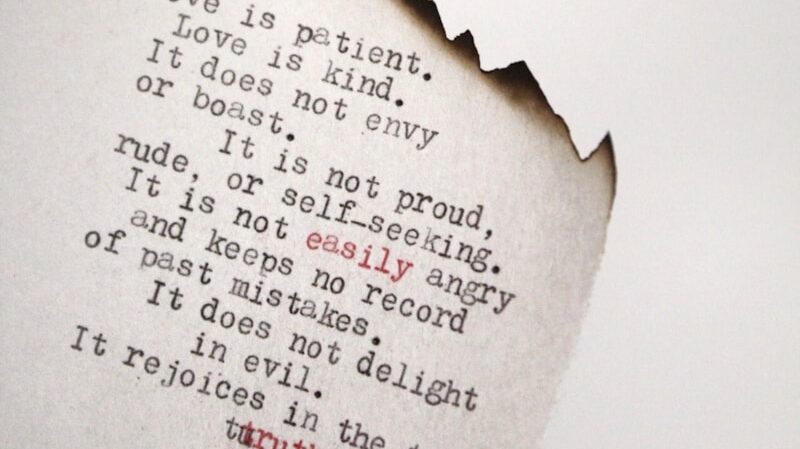 Love is patient Love is kind printed on burned paper